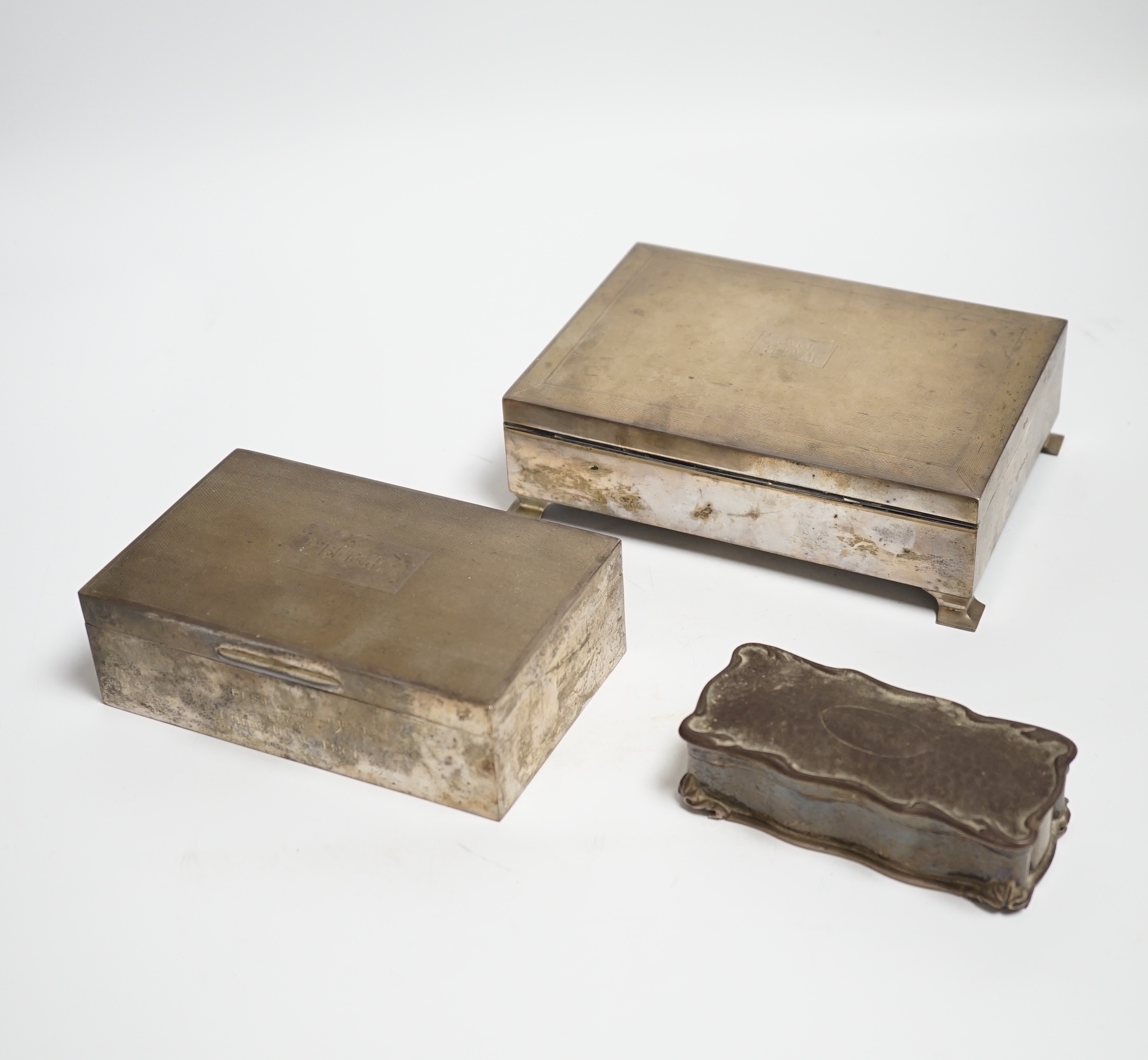 Two engine turned silver mounted cigarette boxes, the largest by Garrard & Co, London, 1955, 16.9cm and a silver trinket box.